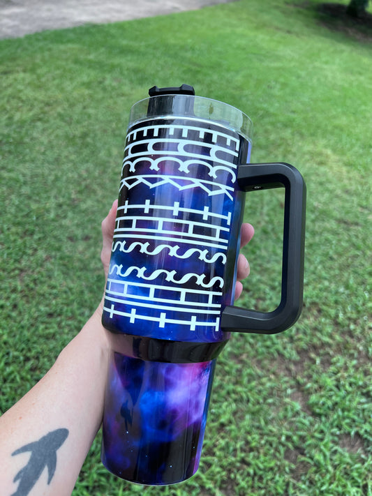 Deep purple and blue galaxy 40oz insulated tumbler with white geometric tribal print and ergonomic handle.