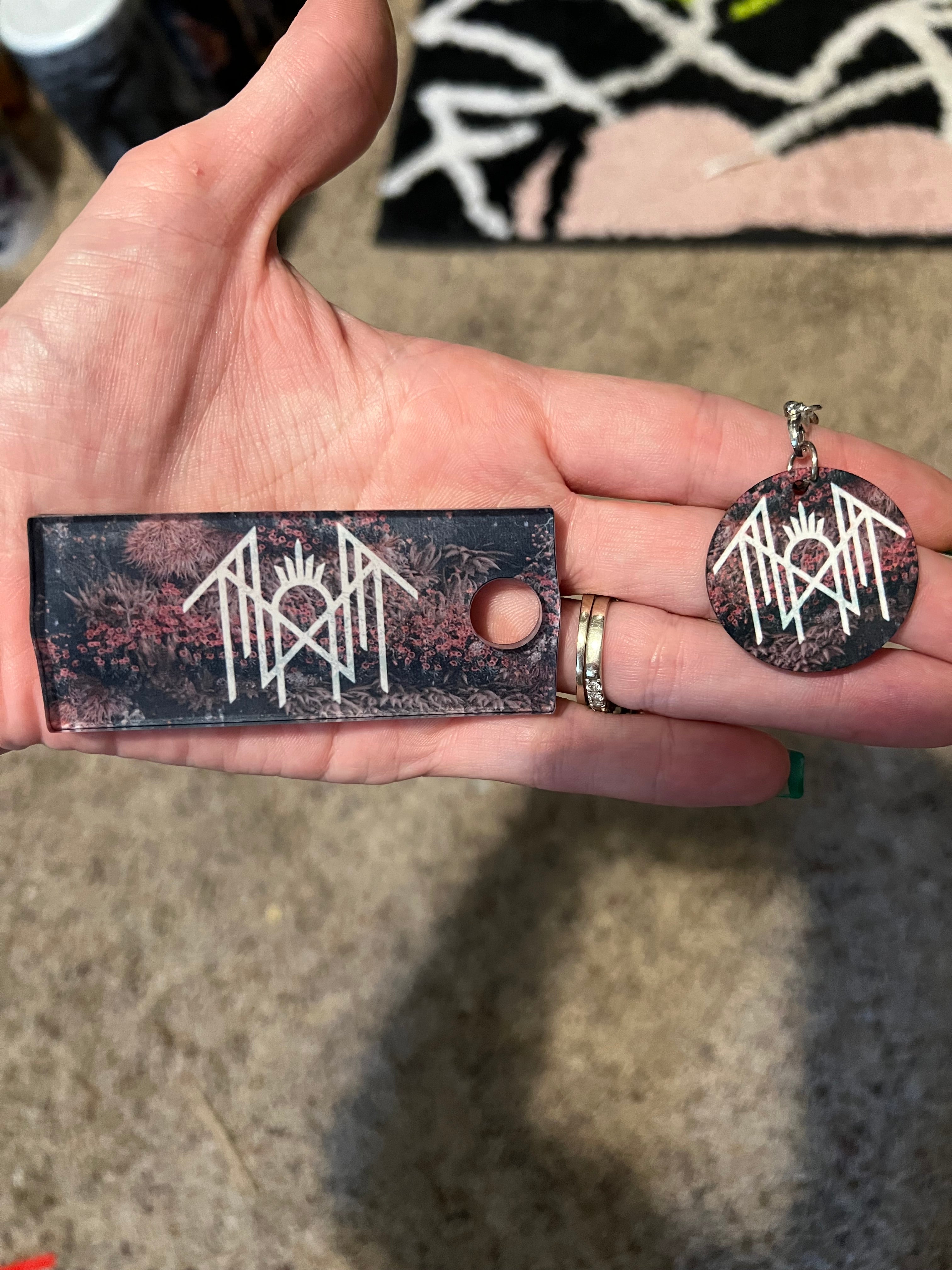 Sleep Token inspired floral sigil tumbler  topper and matching keychain charm held in hand.