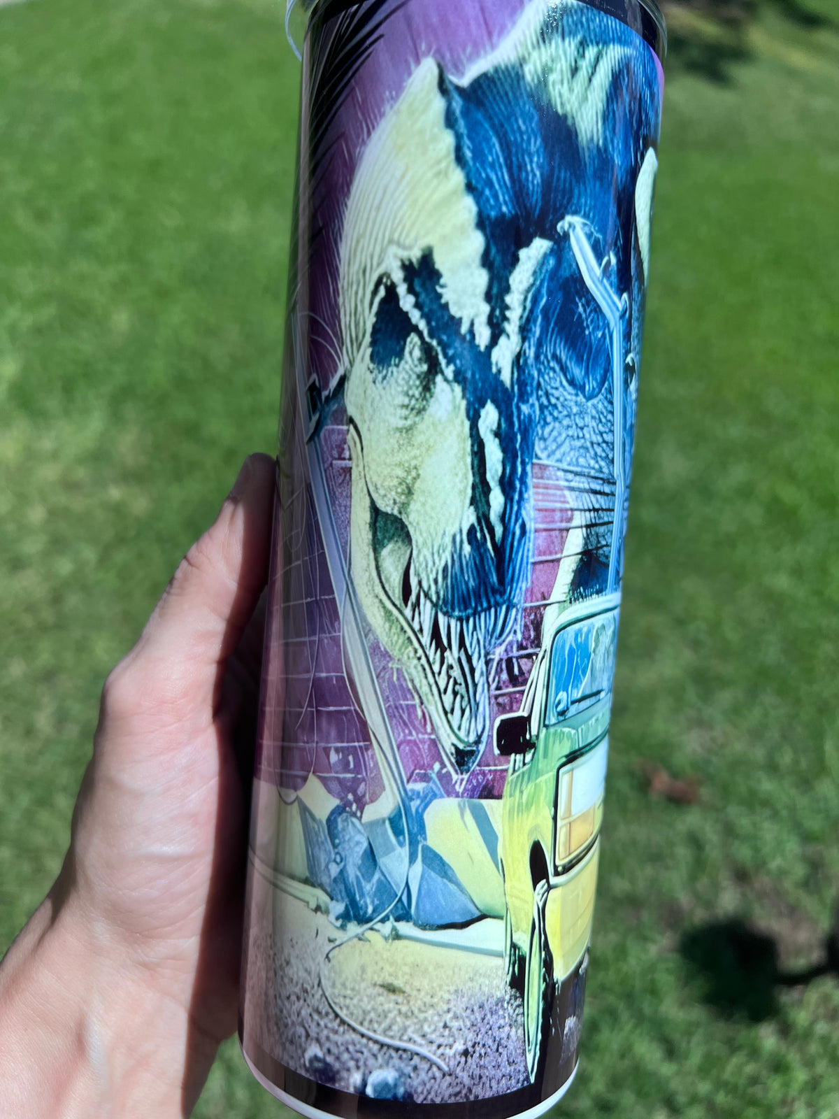 Retro 90s Jurassic Park 20oz skinny tumbler featuring a neon-purple sci-fi wrap with a T-Rex head and tour SUV.⁠