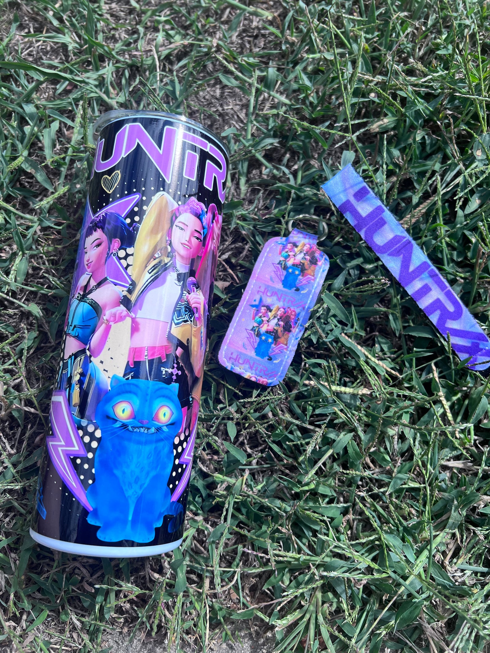 HUNTRIX K-Pop Demon Hunters 20oz tumbler featuring Rumi, Mira, Zoey, and their blue cat familiar with matching keychain set.