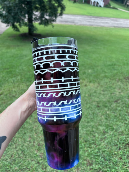 Deep purple and blue galaxy 40oz insulated tumbler with white geometric tribal print and ergonomic handle.⁠