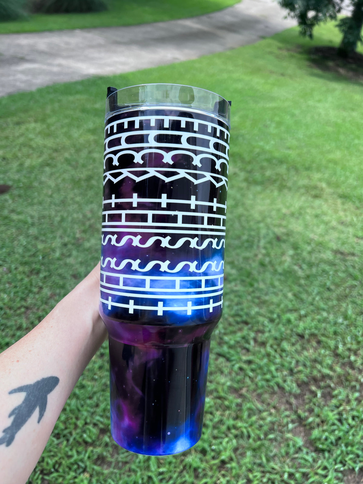 Close-up of a 40oz galaxy tumbler turned sideways to reveal a hidden sarcastic typographic text pattern reading 'Fuck this shit'.⁠