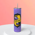 20oz skinny tumbler featuring the Hufflepuff badger house crest centered on a vibrant purple glitter galaxy background, shown in a professional studio setting.