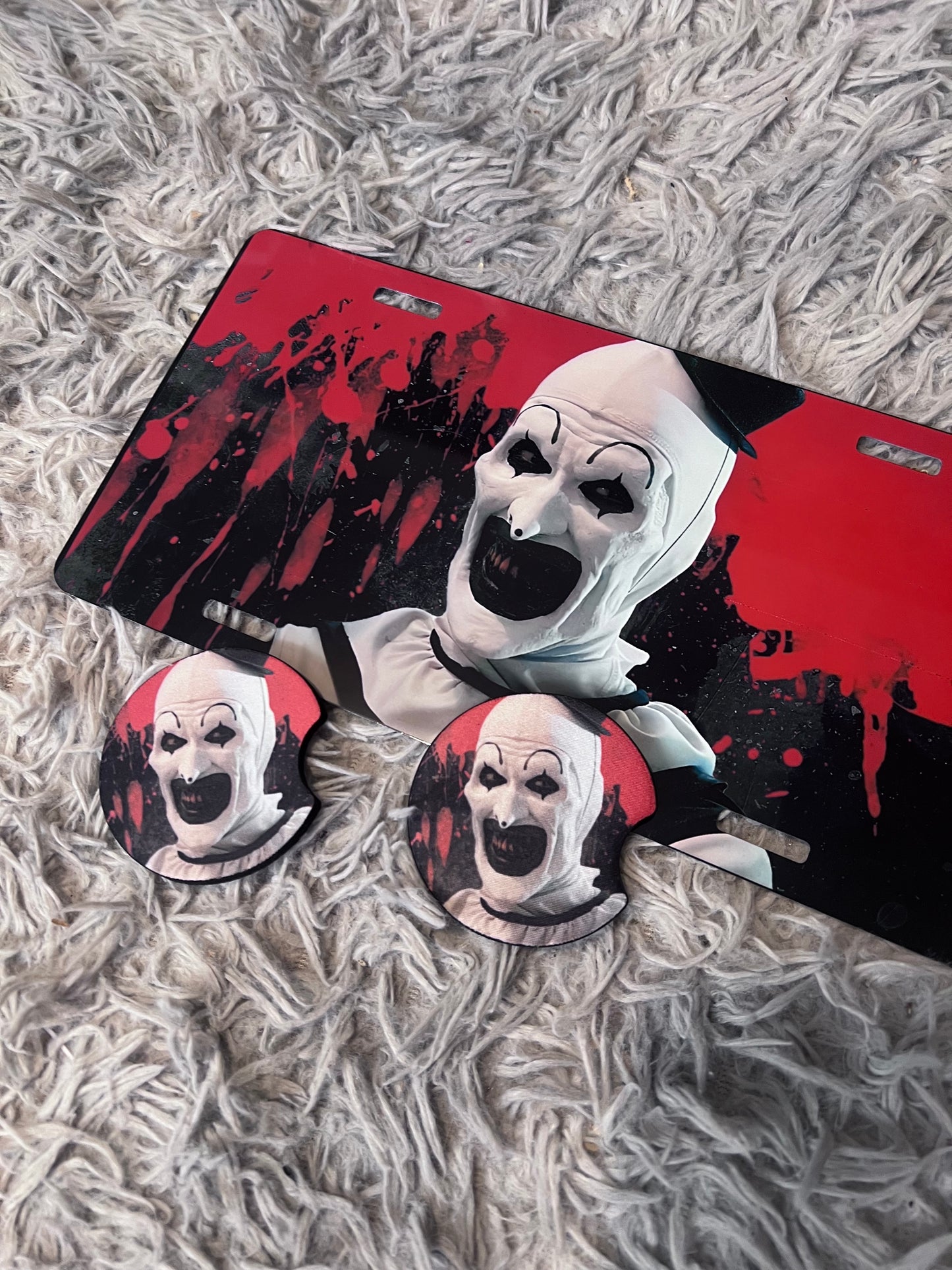 Art The Clown Horror Car Accessory Set | Terrifier Inspired Car Coasters & Vanity Plate | Spooky Horror Fan Car Decor featuring the design artwork
