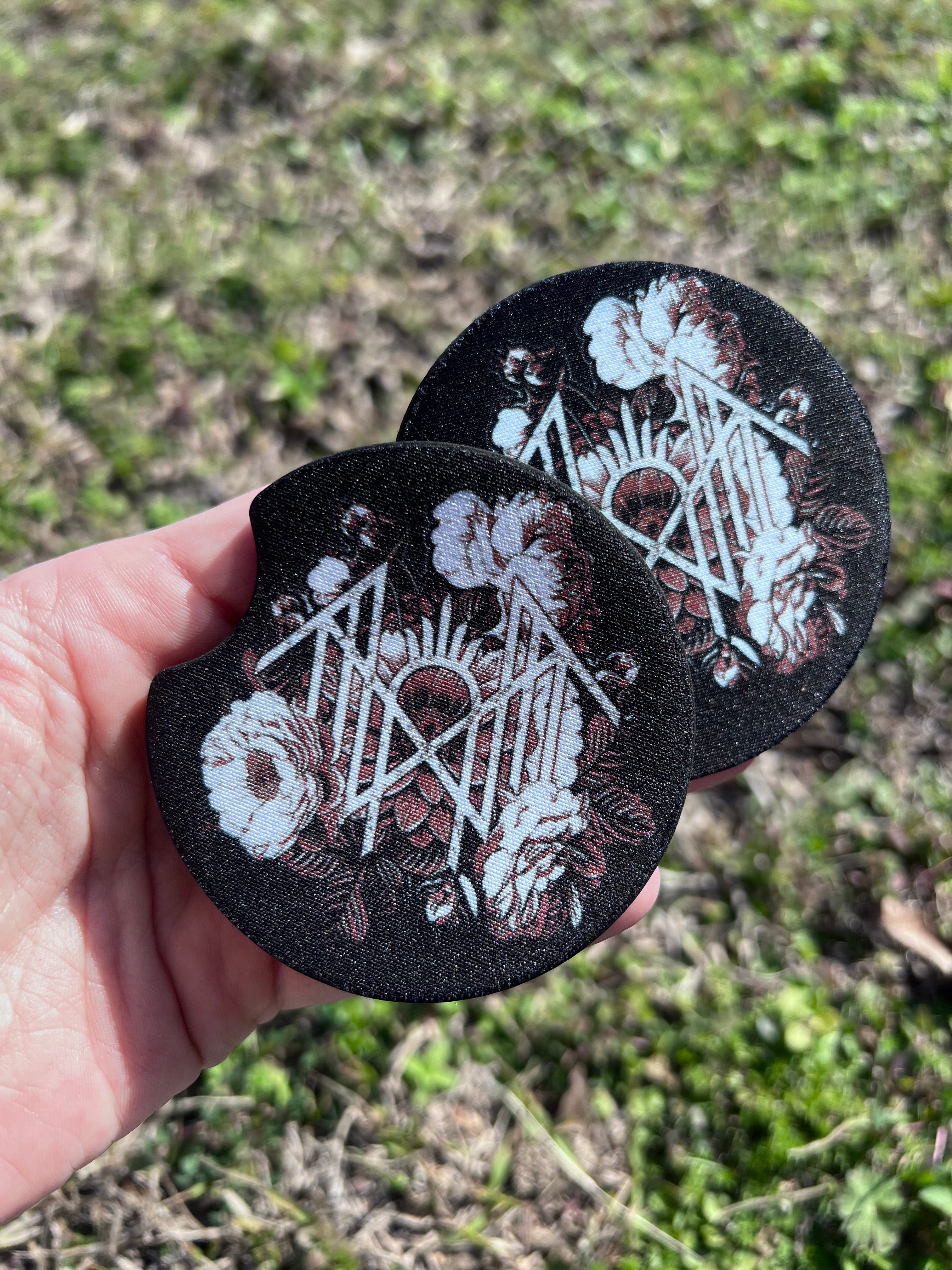 Two circular car coasters featuring a Sleep Token inspired floral sigil design 