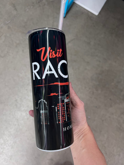A hand holding a custom black tumbler featuring a red and white umbrella logo above a smoky grey and red city skyline.  
 For the Text Fo